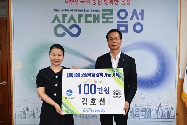 소프트웨어 강사 김호선 씨(왼쪽)가 음성군장학회에 100만원의 장학금을 기탁했다. 오른쪽 조병옥 음성군수.